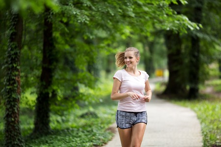 Beautiful athletic  female jogger in natureの写真素材
