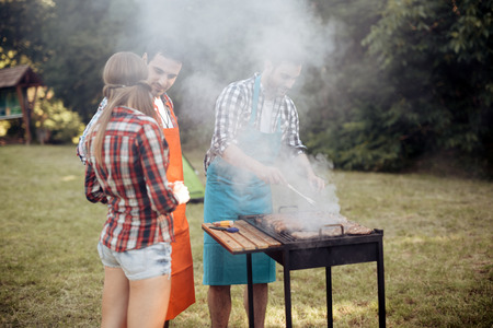 Friends camping and having a barbecue in natureの写真素材