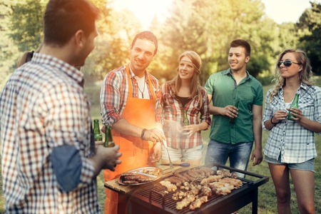 Friends having fun in nature doing bbqの写真素材