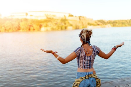 Woman freely spreads arms and enjoys river flowの写真素材