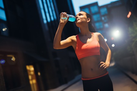 Female runner resting and drinking water