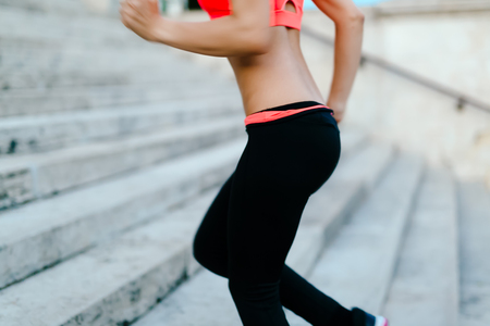 Female sportswoman climbing stairs while trainingの写真素材