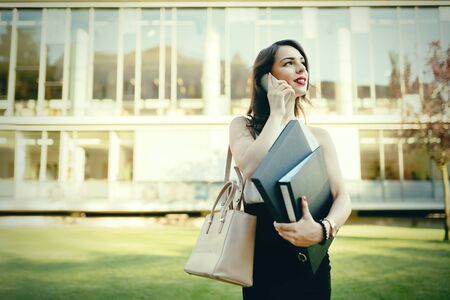 Businesswoman in dress outdoors workingの写真素材