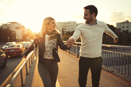 Happy couple jumping from joy in sunsetの写真素材