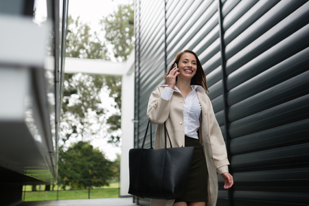 Beautiful smiling businesswoman walking outdoorsの写真素材