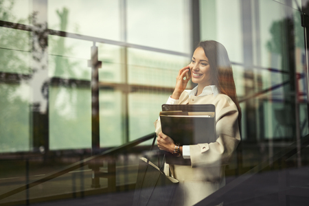 Beautiful businesswoman outdoors holding filesの写真素材