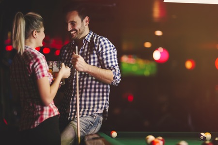 Couple drinking beer playing snooker on dateの写真素材