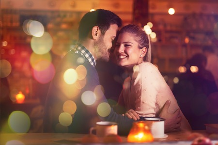 Romantic couple dating in pub at nightの写真素材