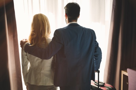Business couple in formal wear in hotel roomの写真素材