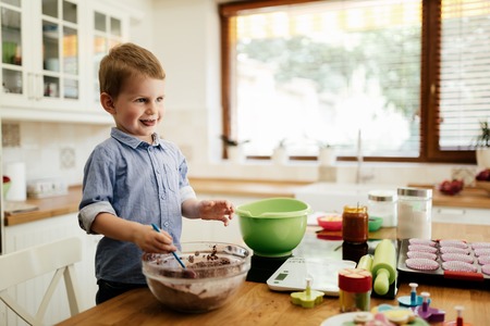 Adorable child below the age of 3  making cookies in kitchen