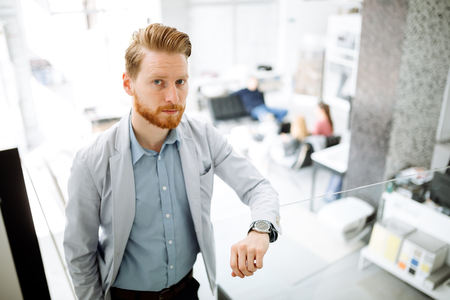 Businessman in suite portrait on stairs in office buildingの写真素材