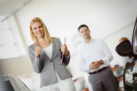 Salesperson selling cars at car dealershipの写真素材