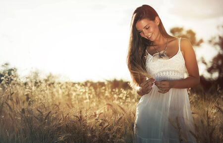 Beautiful carefree woman in wheat meadowの写真素材