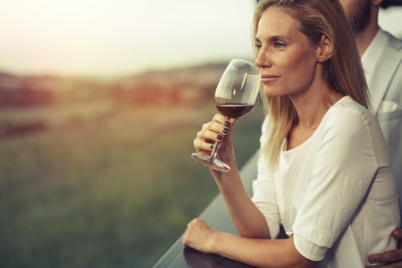 Beautiful woman enjoying wine and sceneryの写真素材