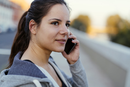 Sportswoman using phone after jogging in cityの写真素材