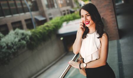 Beautiful businesswoman using smart phone outdoors