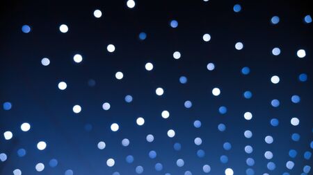 Defocused xmas  lights at night making white bokehの写真素材