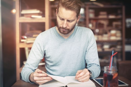 Cheerful student studying for university in library