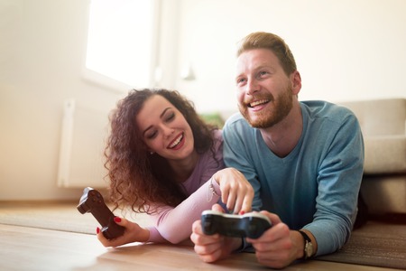 Happy couple playing video games  on console and having fun