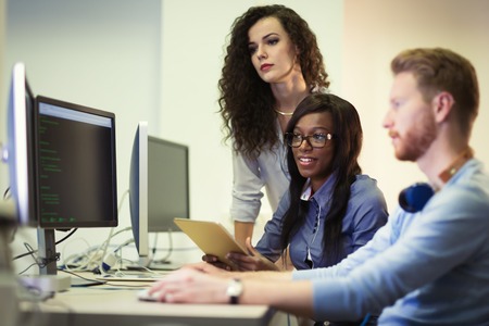 Programmers cooperating at  IT company developing apps