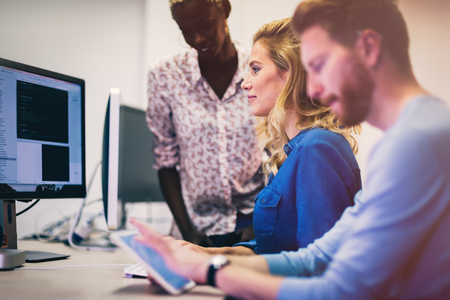 Programmers and business people collaborating in company officeの写真素材