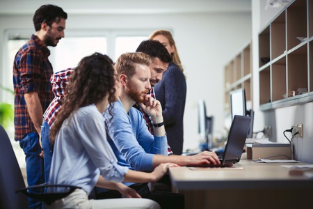 Programmers and business people collaborating in company officeの写真素材