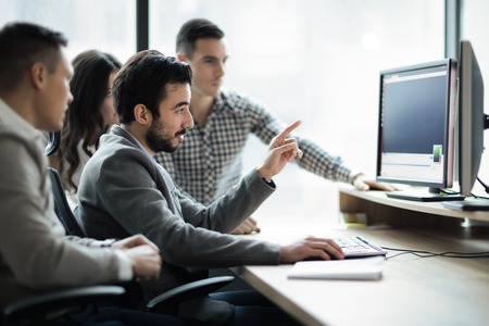 Software engineers developing applications together in officeの写真素材