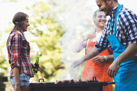 Friends having a barbecue party in nature  while having a blastの写真素材