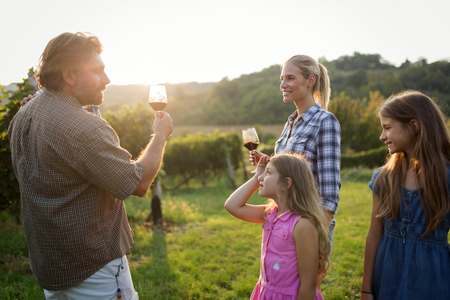 Happy winegrower family in vineyard before harvestingの写真素材