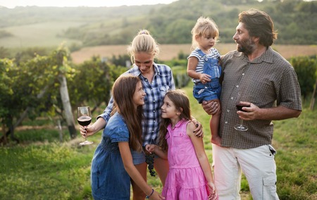 Winemaker family happy together in vineyard before harvestingの写真素材