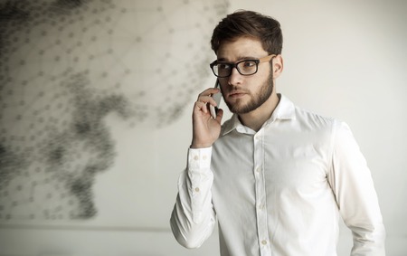 Businessman holding mobile device in cafe on business breakの写真素材