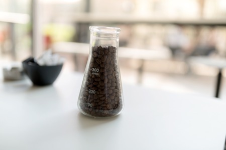 Dark roasted coffee beans on table in restaurant in glassの写真素材
