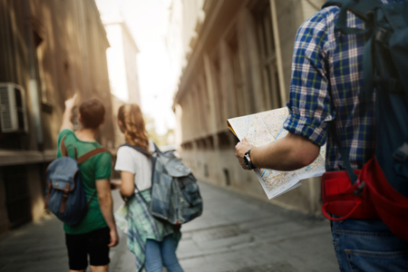 Young happy tourists holding map sightseeing in cityの写真素材