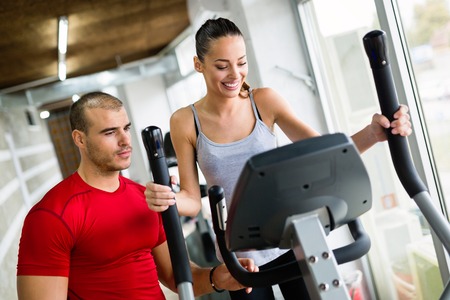 Personal trainer helping woman reach goals in gym