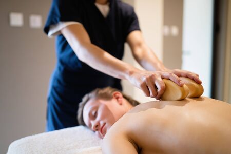 Cliend enjoying massage treatment given by masseurの写真素材
