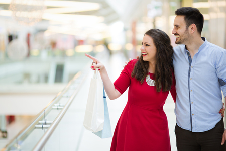 Beautiful couple enjoy shopping together in shopping mallの写真素材