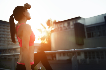 Beautiful sportswoman jogger doing her run in sunsetの写真素材