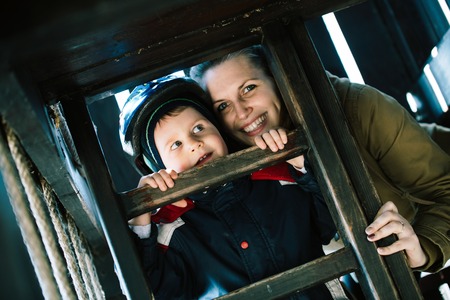 Happy mother smiling and playing with son outdoor