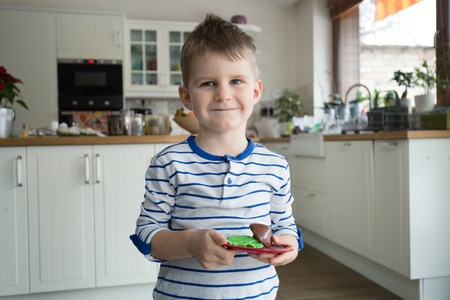 Happy young boy playing to be chef in kitchenの写真素材