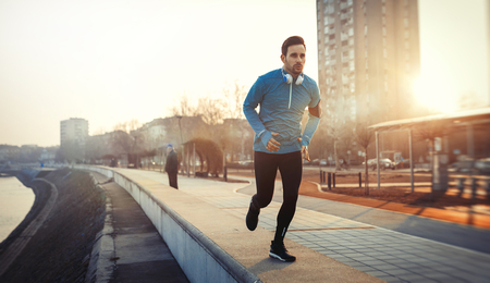 Handsome sportsman exercising outdoor by jogging and runningの写真素材
