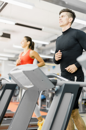 Group of young people running on treadmills in a fitness centerの写真素材