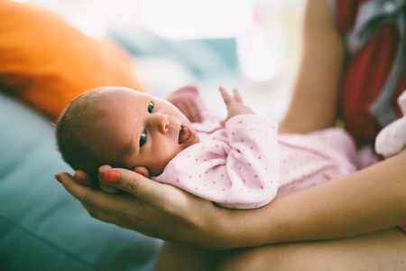 Mother proudly holding beautiful little newbornの写真素材