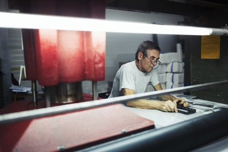 Worker working on pattern cutting industrial machineの写真素材