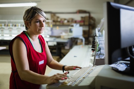 Female employee working on clothing fabric productionの写真素材