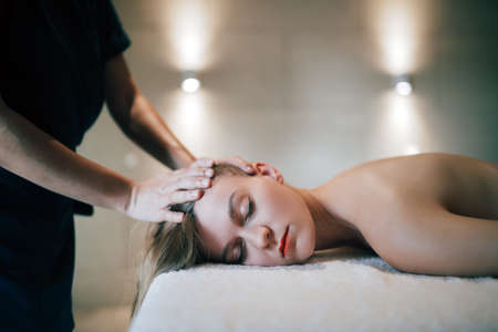 Rejuvenating relaxing massage by masseur at massage saloonの写真素材