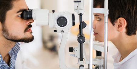optometrist checking patient eyesight and suggesting vision correction treatments