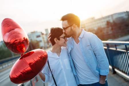 smiling couple in love with balloons on sunset dating on Valentine dayの写真素材
