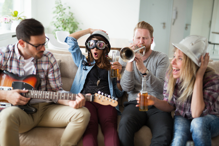 Happy group of friends playing instruments and partyingの写真素材