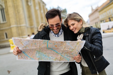 Smiling young attractive couple looking at mapの写真素材