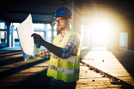 Picture of construction site engineer looking at plan